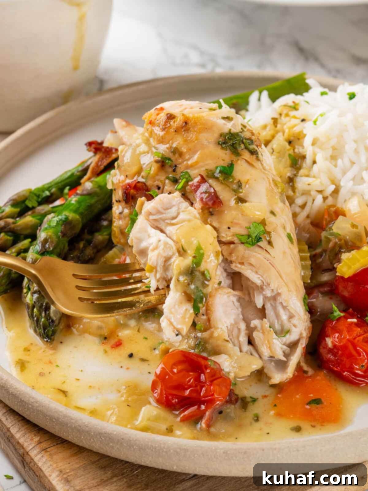 Golden-brown chicken in white wine sauce, garnished with fresh herbs and blistered tomatoes, served in a skillet with a gold fork.