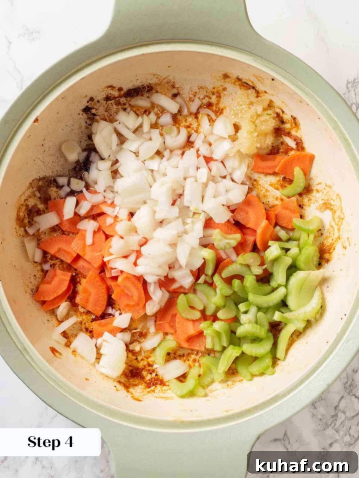 Chopped onions, carrots, and celery in a skillet, ready to be sautéed for chicken in wine sauce.