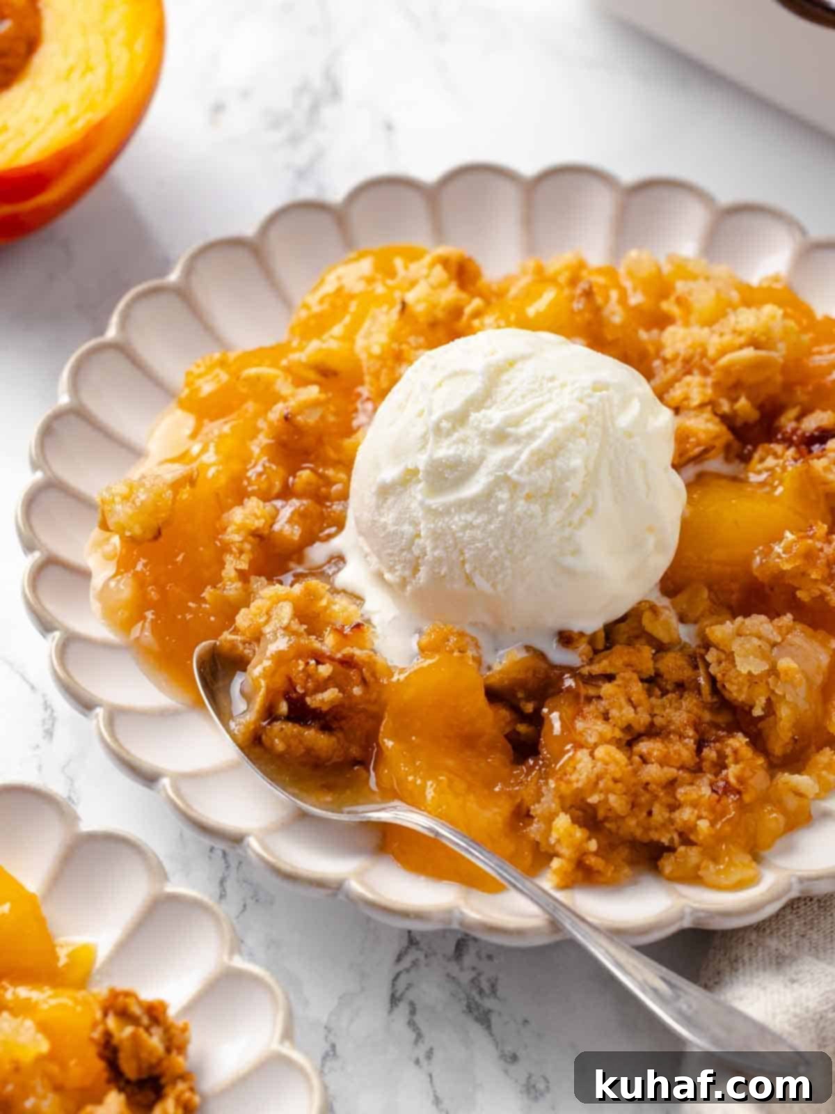 A scoop of ice cream in a bowl served with peach crisp.