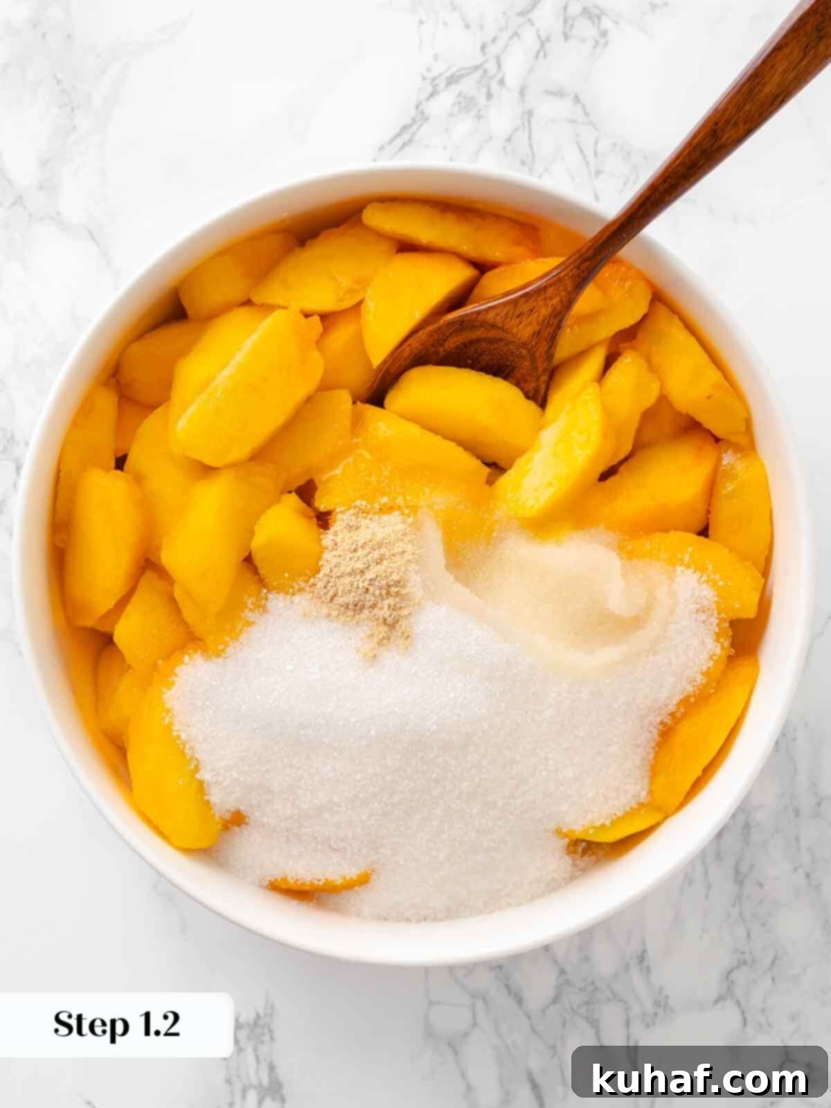 Sliced peaches mixed with sugar, beginning the peach crisp preparation.