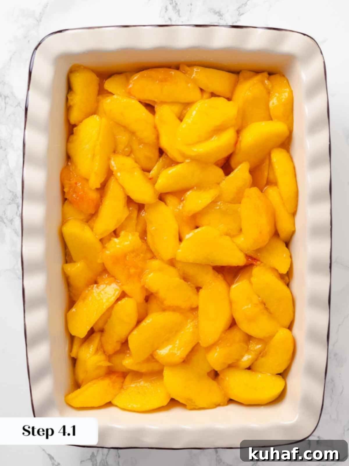Peach mixture spread in a baking dish, ready to be topped with streusel.