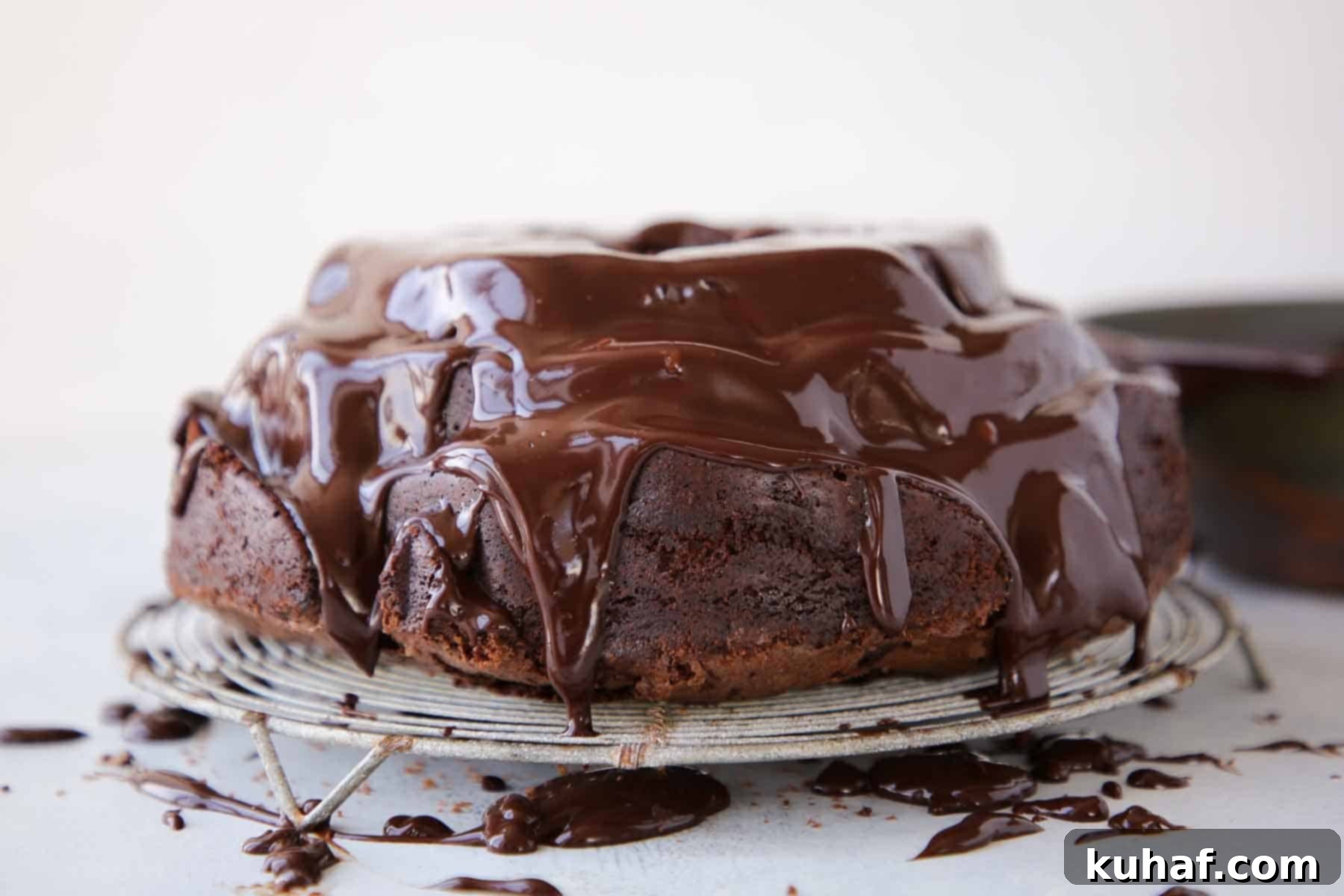 dripping ganache over chocolate bundt cake on vintage wire rack.