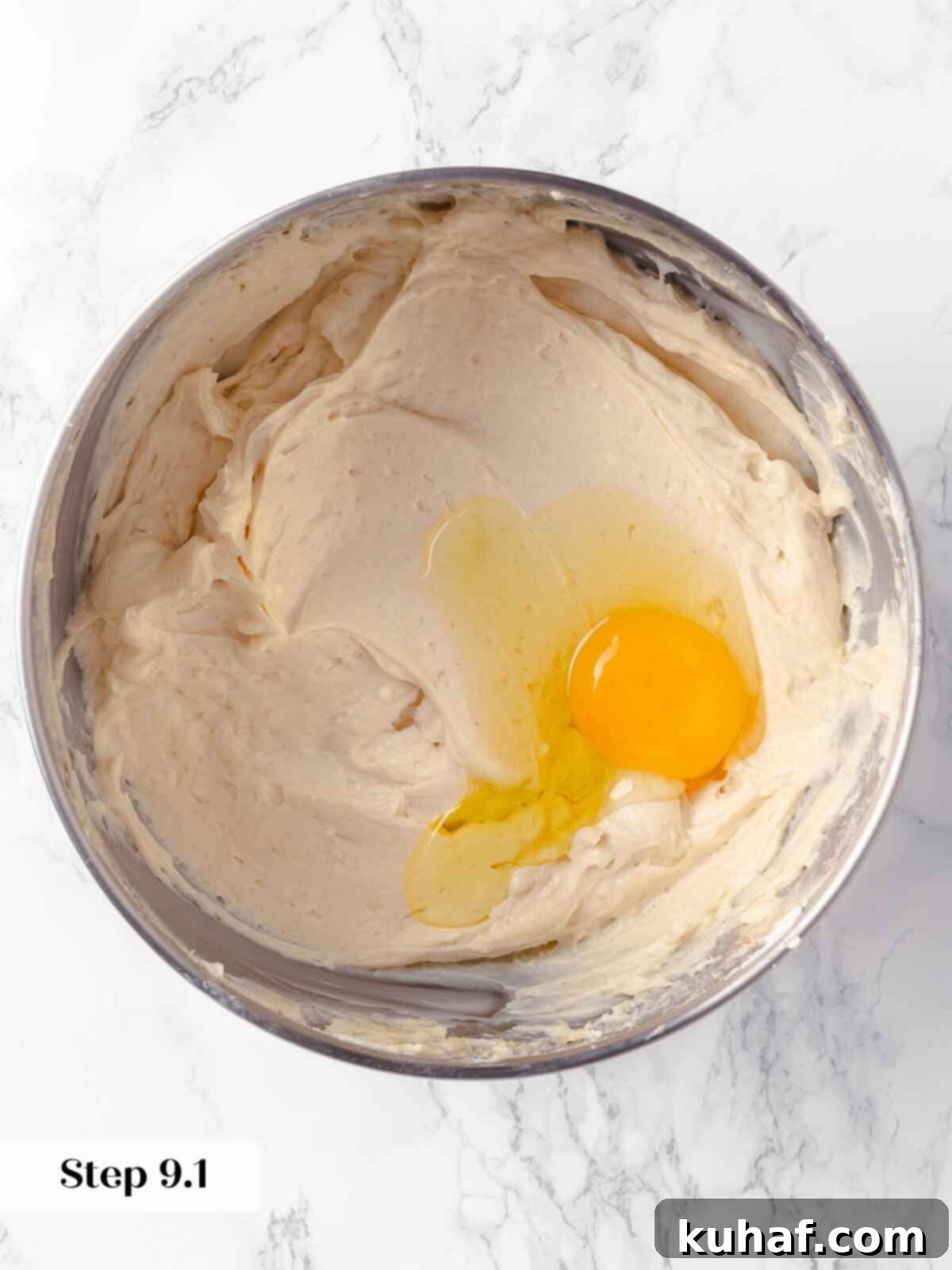 Decadent Pumpkin Cheesecake 13 Adding eggs one by one to the pumpkin cheesecake batter in a stand mixer.