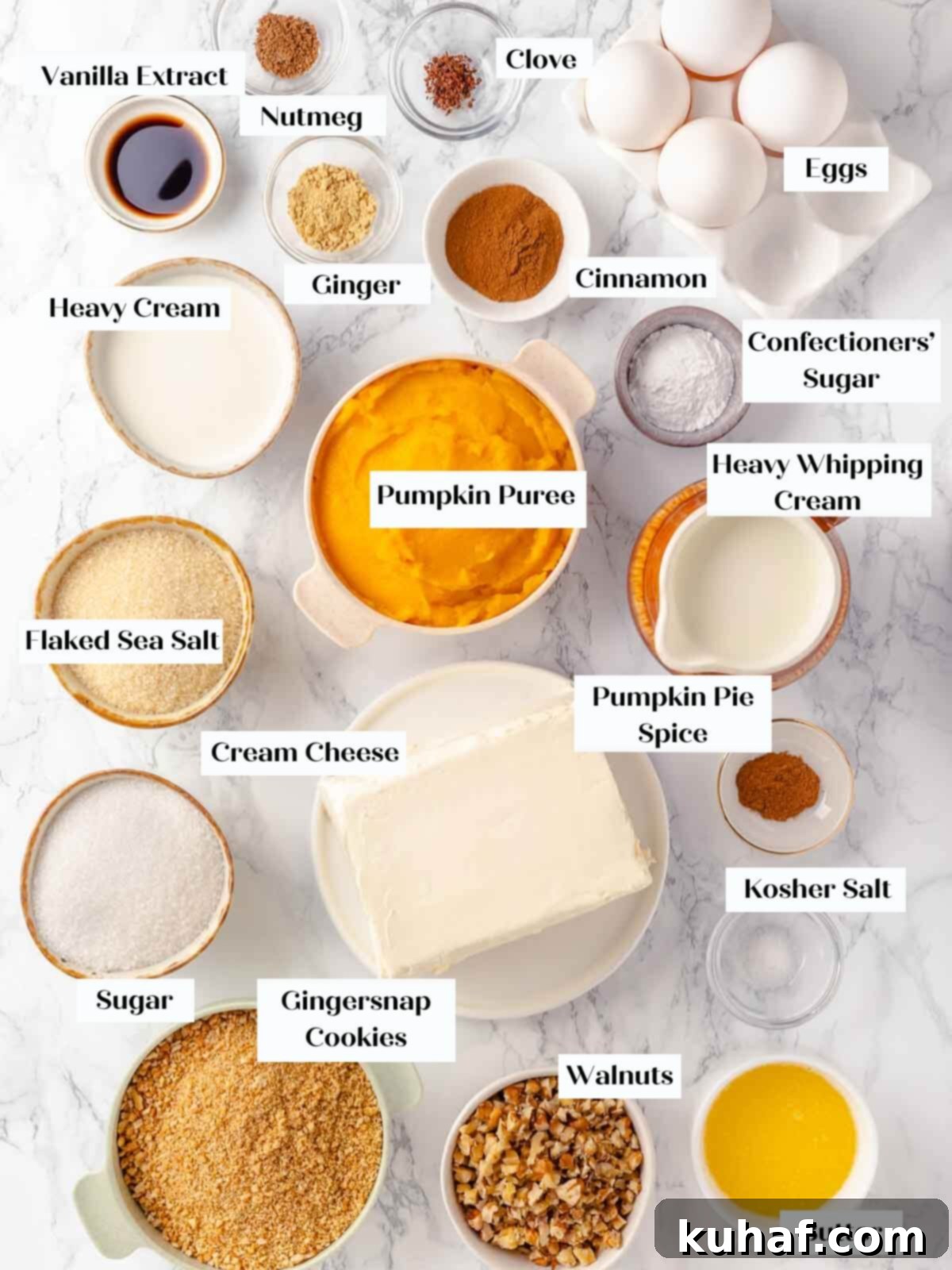 Decadent Pumpkin Cheesecake 4 Pumpkin cheesecake ingredients meticulously arranged on a clean white marble countertop, ready for baking.
