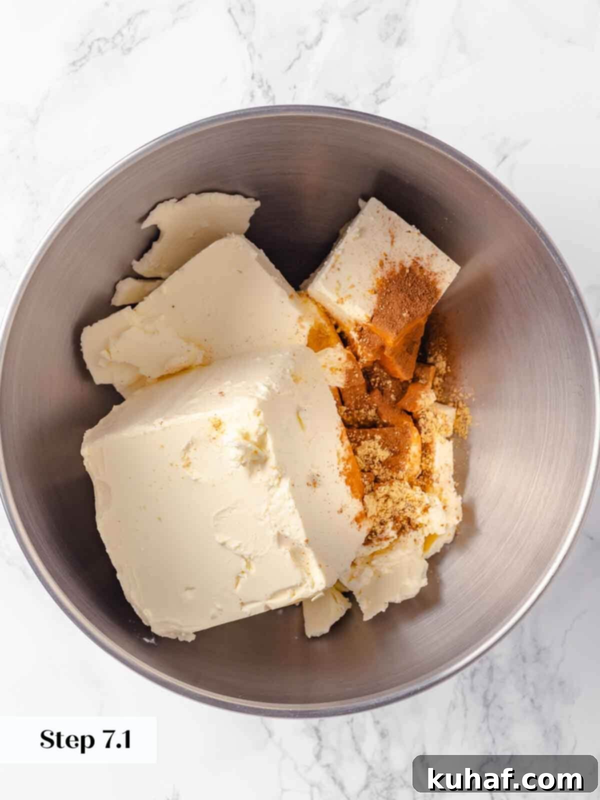 Decadent Pumpkin Cheesecake 9 Unbeaten blocks of room temperature cream cheese in a stand mixer bowl, ready for whipping.