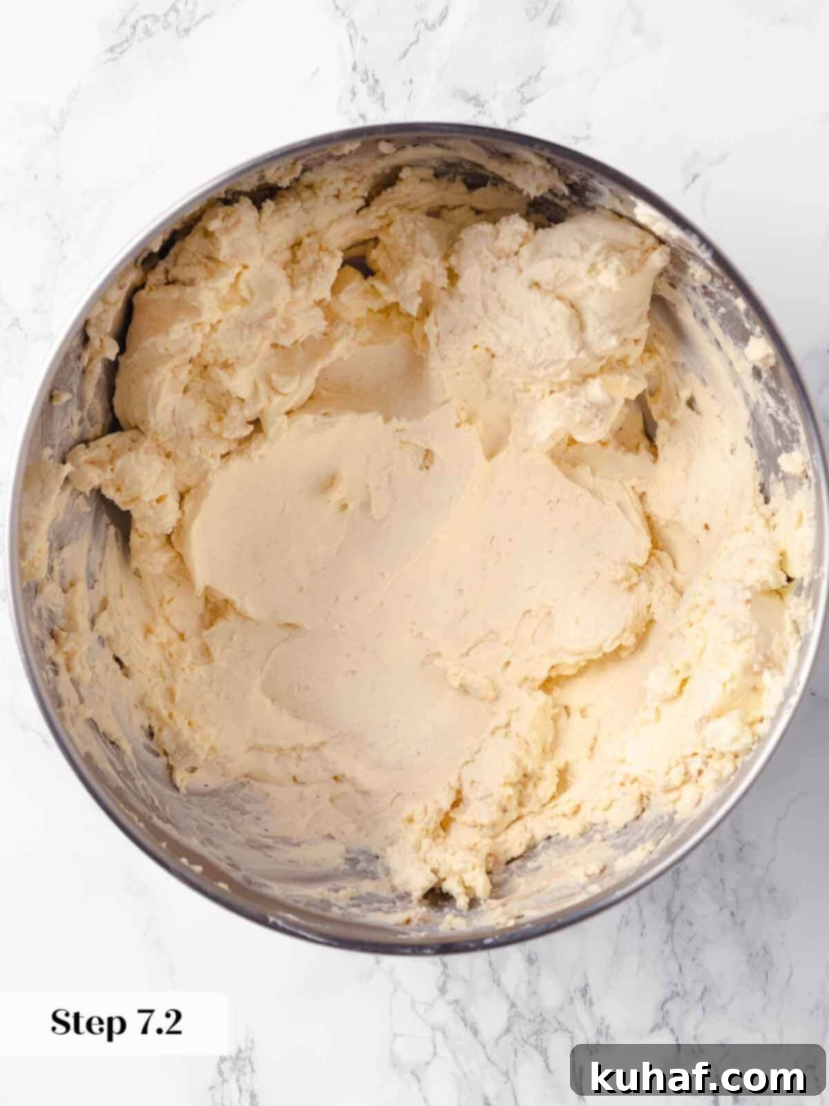 Decadent Pumpkin Cheesecake 10 Creamy, smooth, and well-beaten cream cheese in a stand mixer bowl, ready for further ingredients.