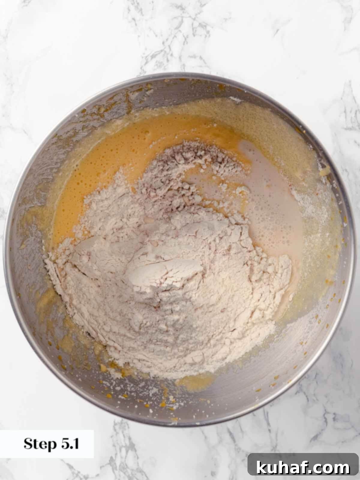 Adding dry ingredients to the apple cider donut mixture.