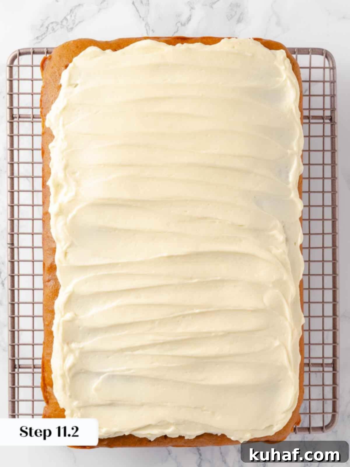 Delicious Autumn Pumpkin Squares 16 Frosting being spread smoothly over the pumpkin bars.