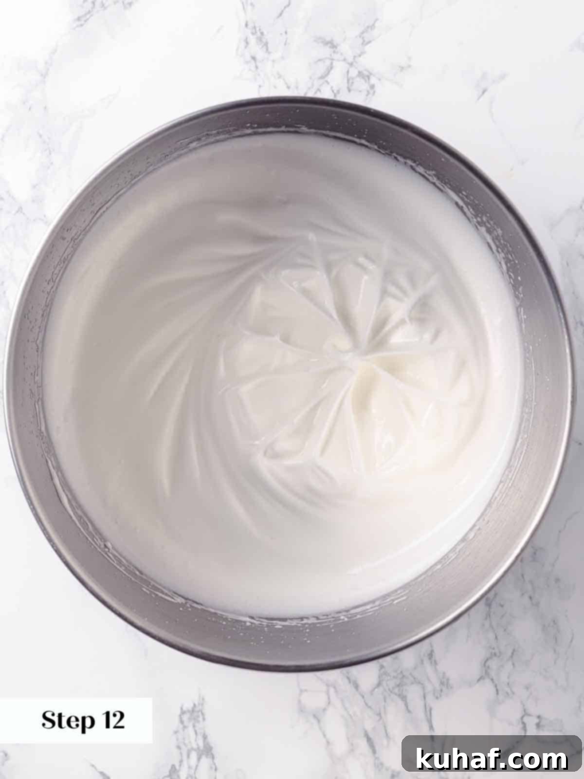 Beautifully whipped egg whites forming a fluffy consistency, demonstrating the soft peaks stage in preparation for a perfect meringue.