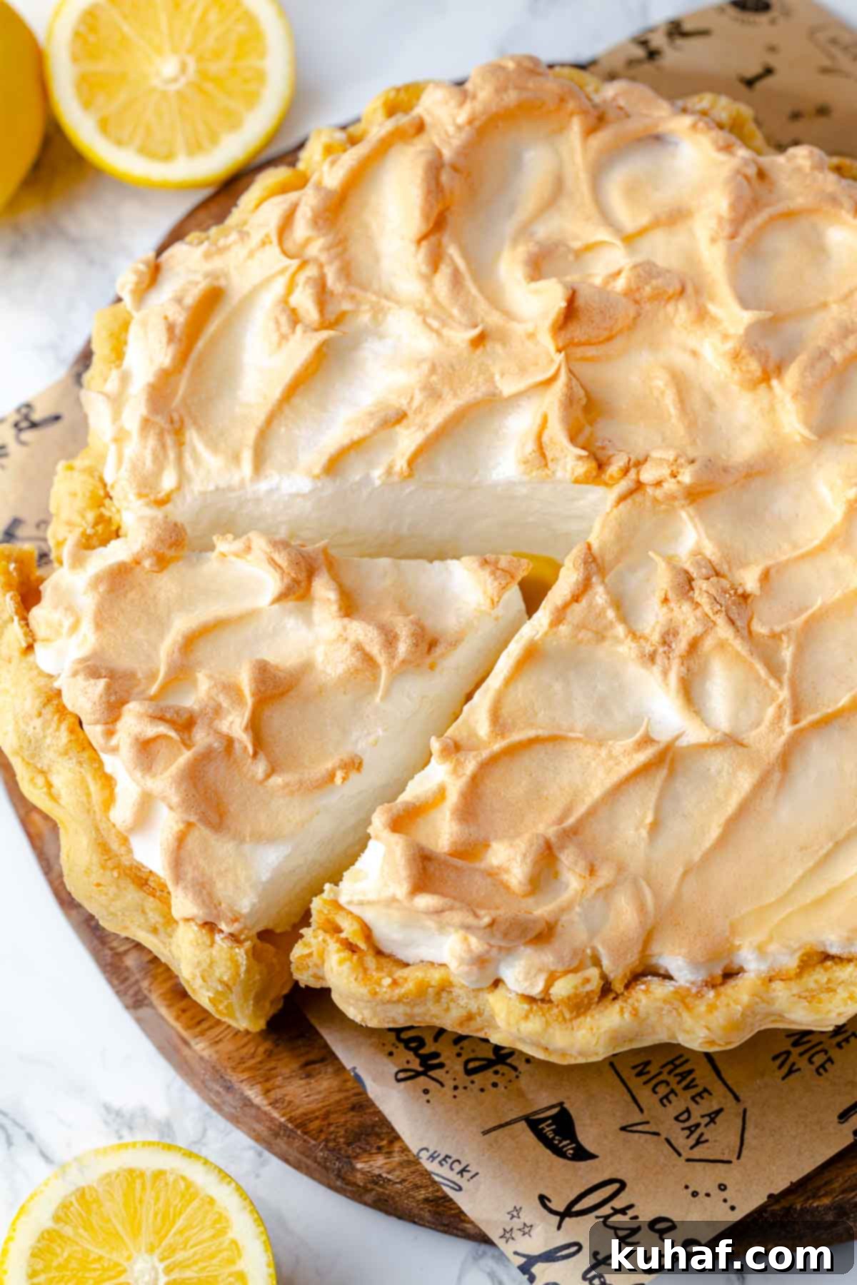 A freshly baked lemon meringue pie, with vibrant whole lemons artfully arranged in the soft-focused background, emphasizing its fresh ingredients.