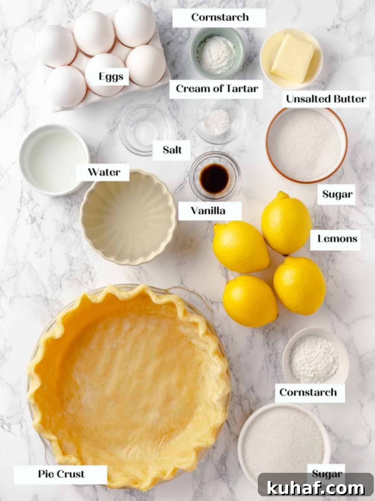 A beautifully arranged display of fresh lemons, eggs, butter, and other baking ingredients on a clean white marble surface, ready for making lemon meringue pie.