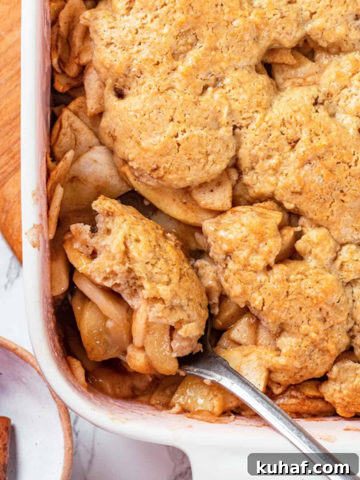 Baked apple cobbler with a perfectly golden brown biscuit topping, ready to be served.