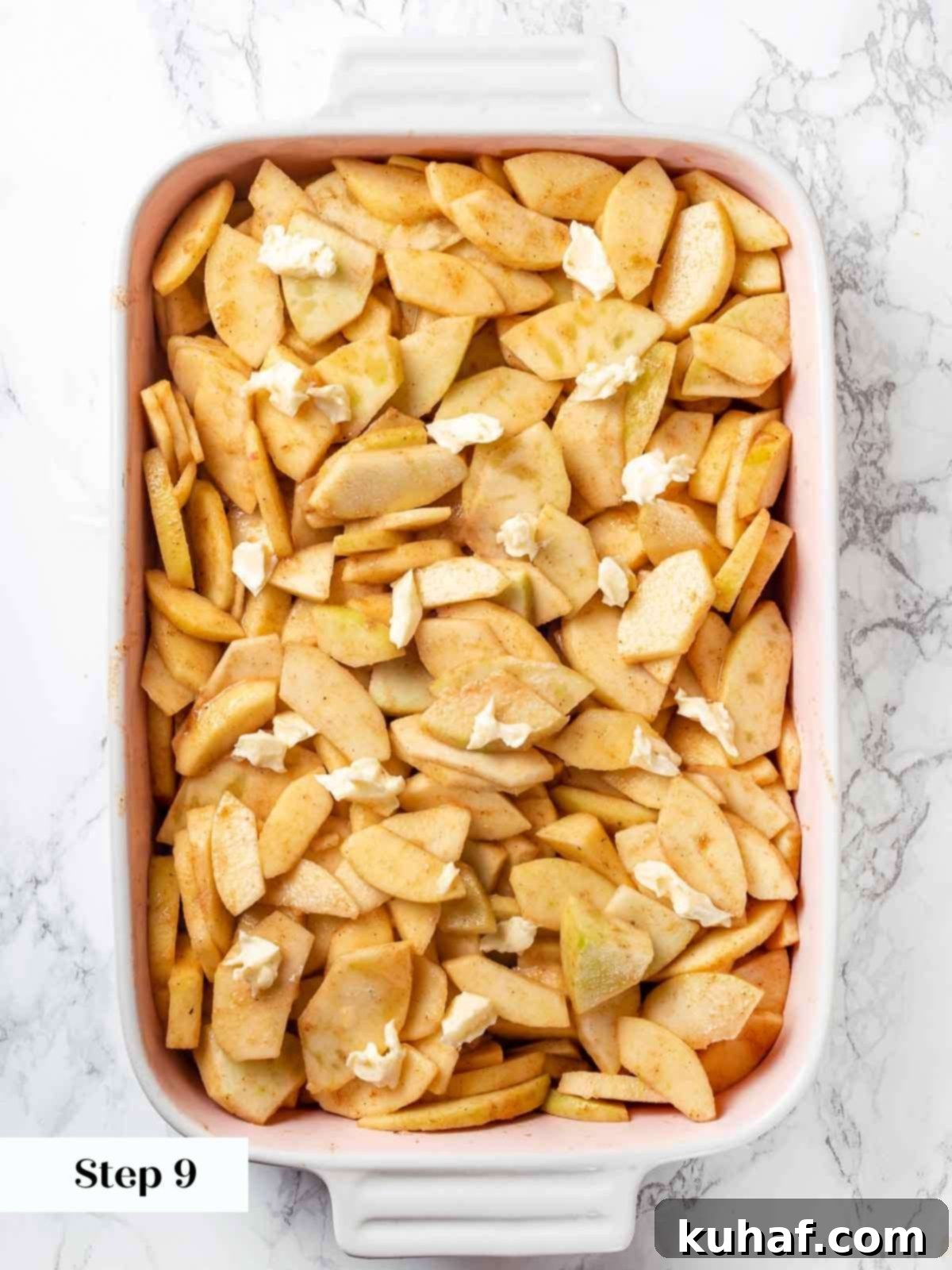 Apple cobbler filling dotted with small pieces of butter before the biscuit topping is added.