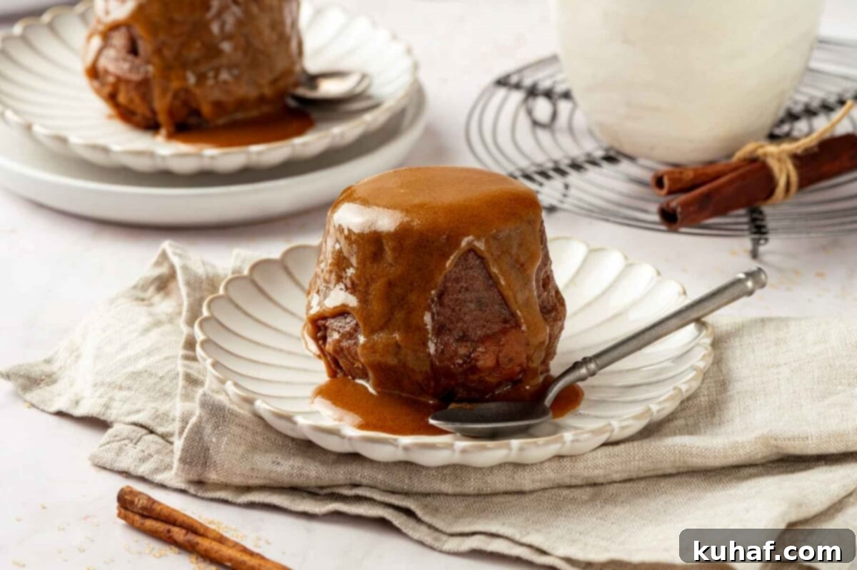 Sticky toffee pudding served on a set of white plates.