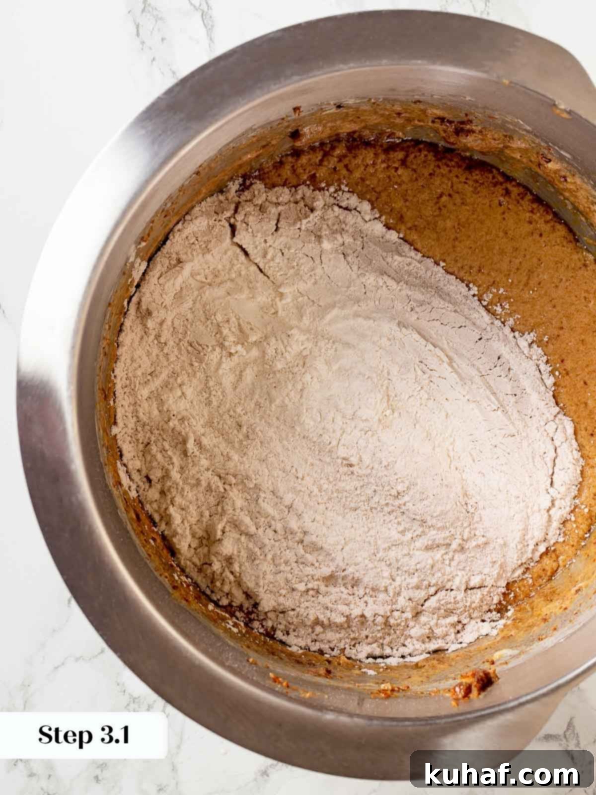 Flour and cinnamon being mixed into the sticky toffee pudding batter.