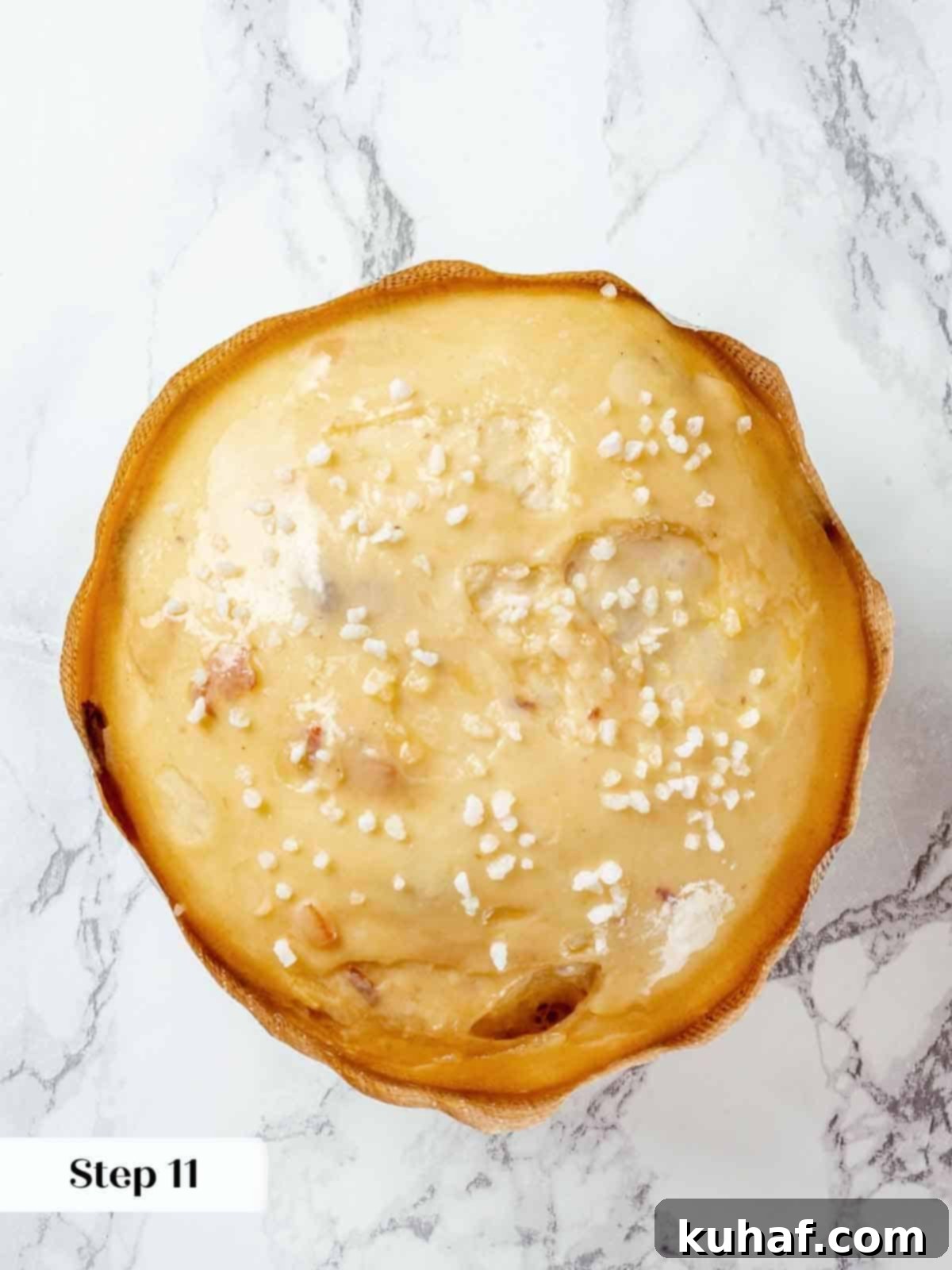 A close-up of sparkling pearl sugar topping delicately sprinkled on proofed panettone dough, ready for baking.
