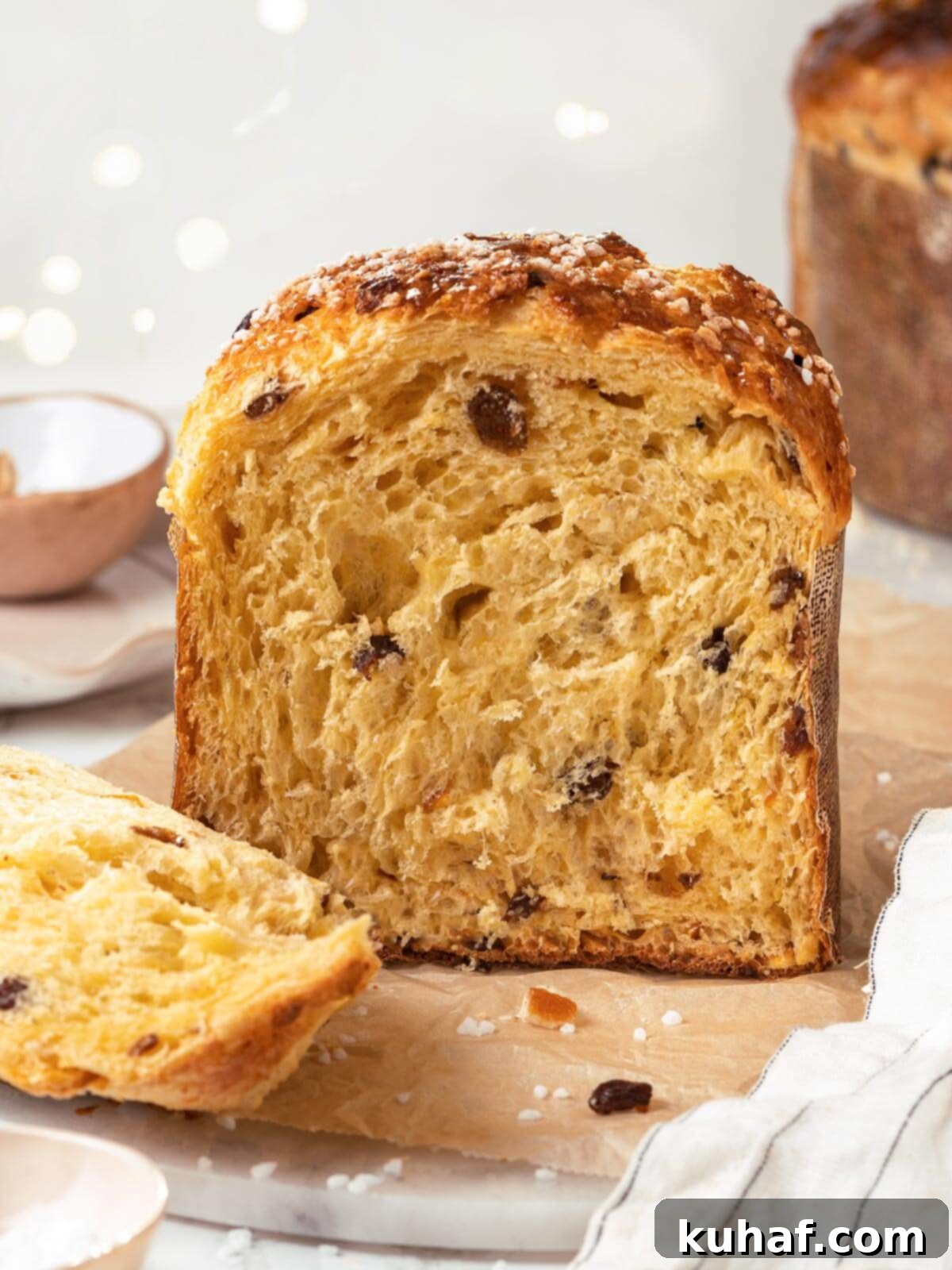 A beautifully baked loaf of panettone, sliced to reveal its incredibly fluffy, airy interior with perfectly distributed fruits.