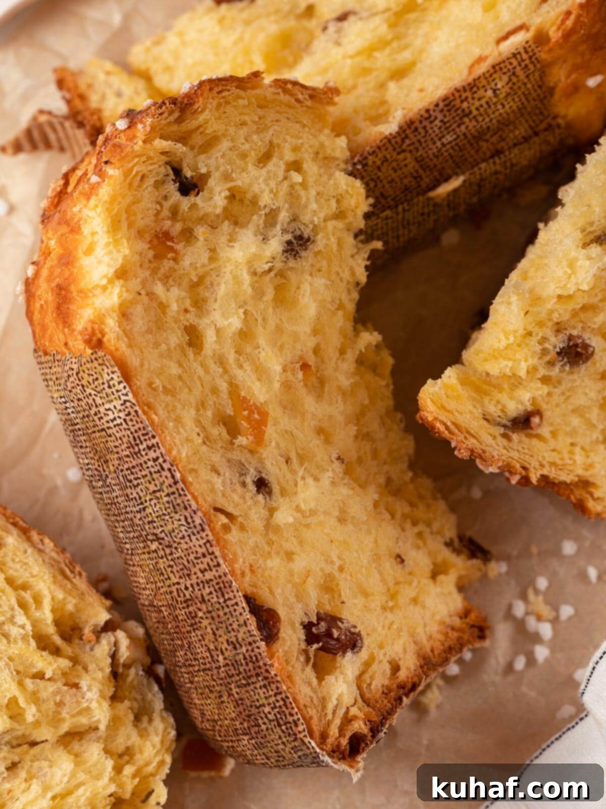 A second slice of perfectly baked panettone, revealing its rich, buttery interior and abundant fruit distribution.