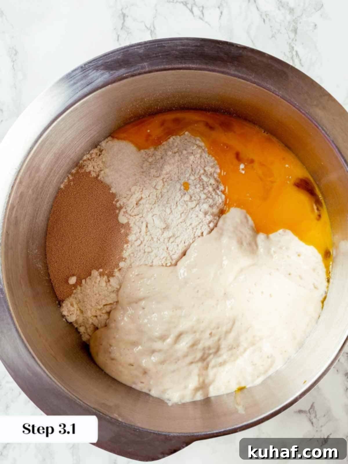 Egg yolks and dry ingredients being mixed in a stand mixer to start the panettone dough, illustrating the initial stage.
