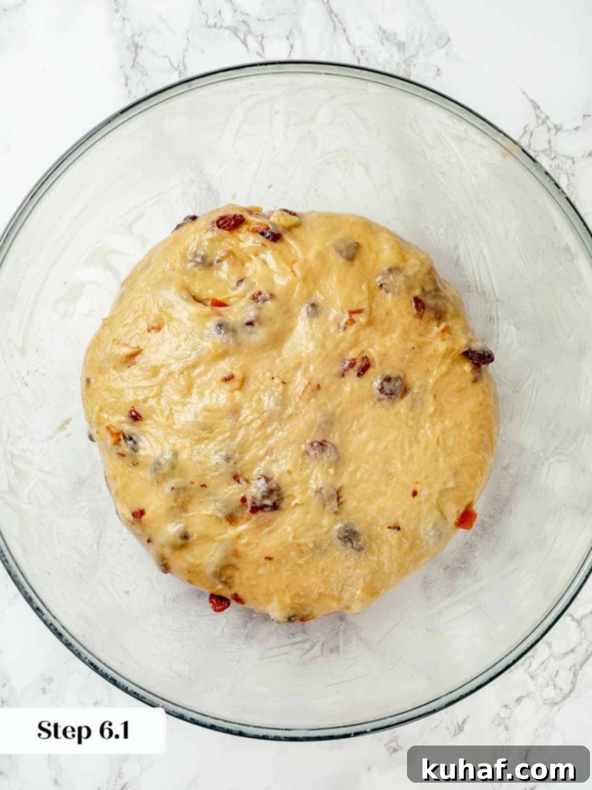 The enriched panettone dough resting and rising in a lightly oiled bowl, covered for bulk fermentation.