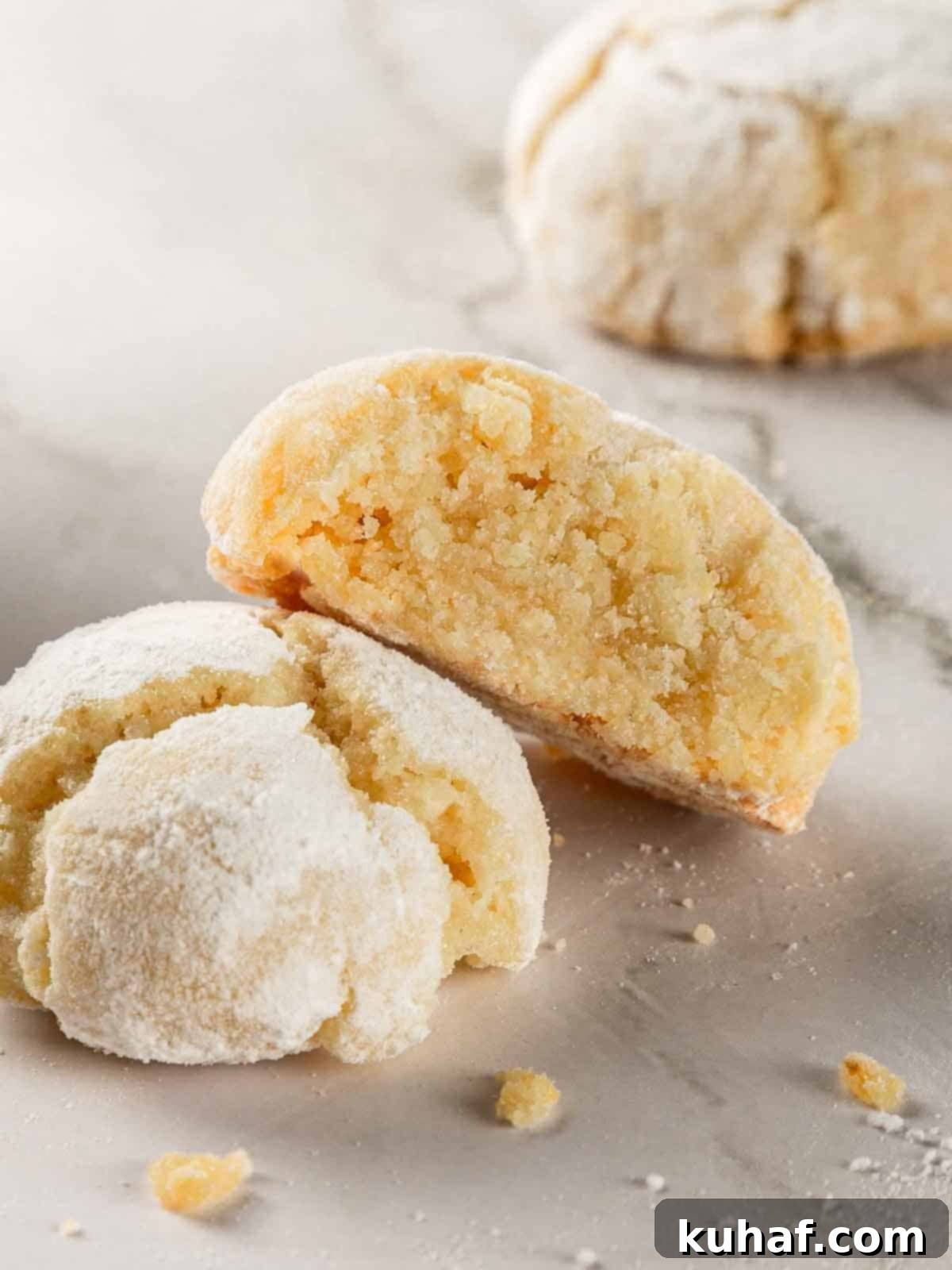 Classic Amaretti Cookies 2 Close-up of baked soft amaretti cookies, dusted with powdered sugar, showing their characteristic crinkled tops.