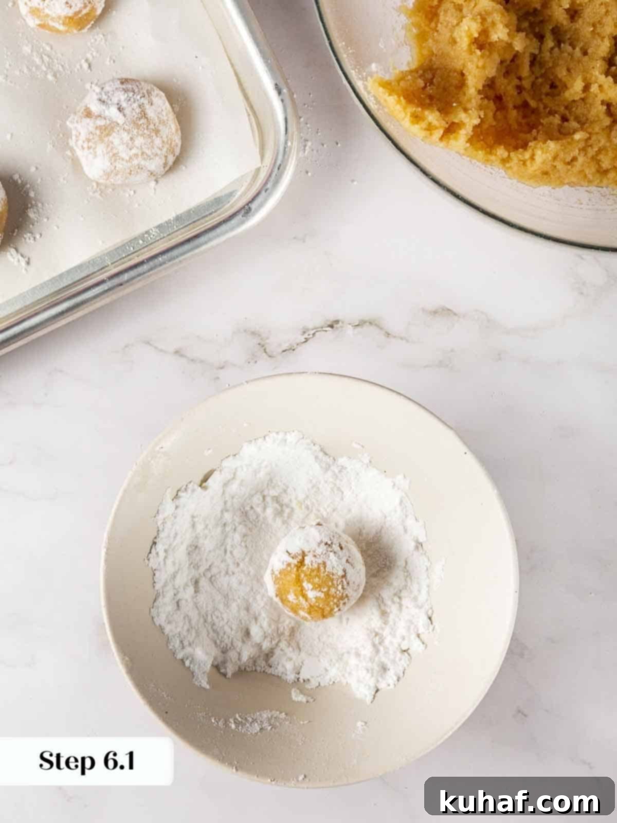 Classic Amaretti Cookies 9 Step-by-step image showing cookie dough being rolled in powdered sugar.