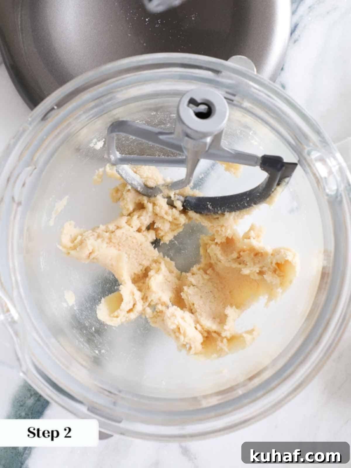 Close-up of butter and sugars perfectly creamed together in a mixing bowl, forming a smooth, light base for monster cookie dough.