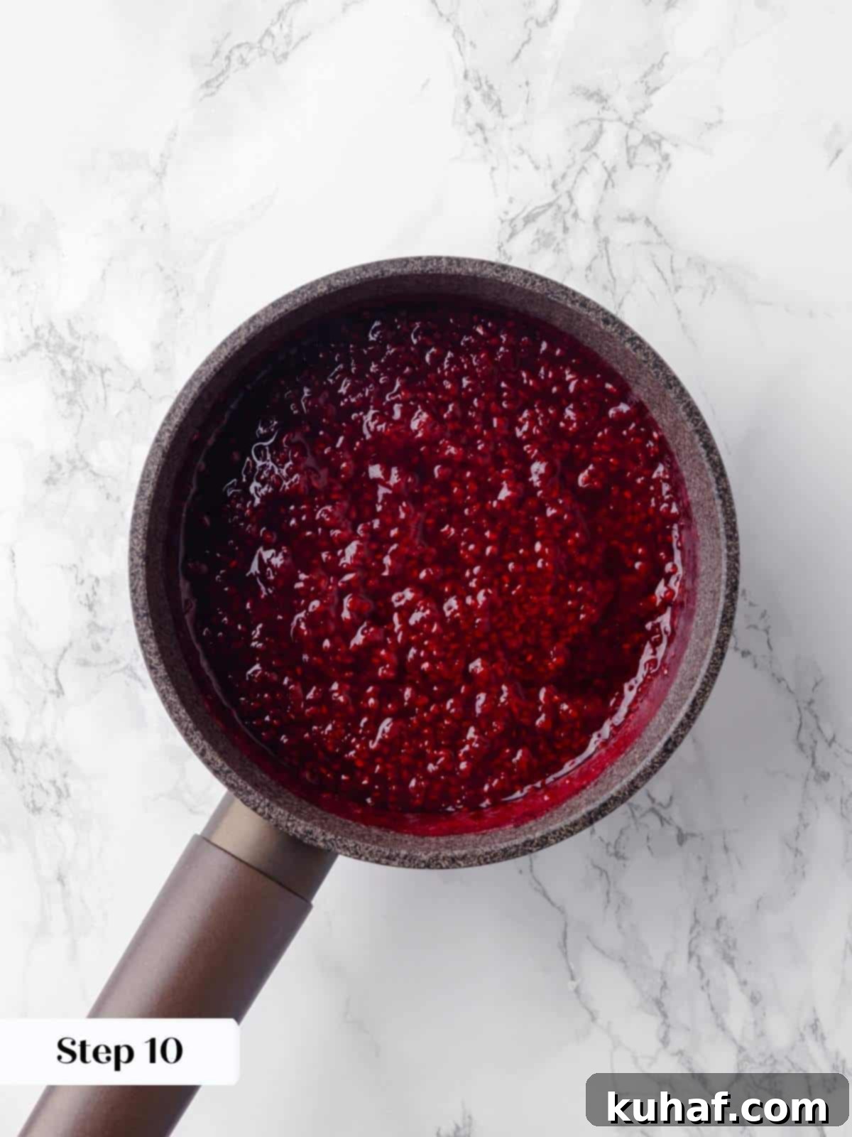 Fresh raspberries simmering in a saucepan, releasing their juices to create a rich and flavorful quick jam for the cake.