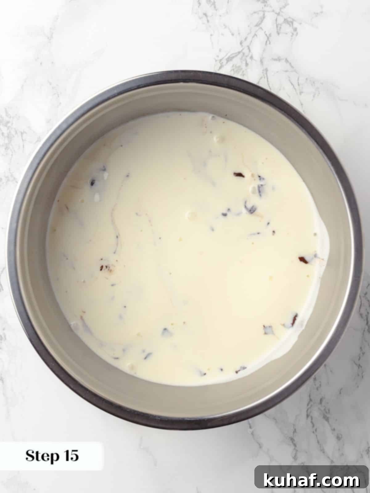 Hot, steaming cream being poured over chopped chocolate pieces, initiating the creation of a smooth, decadent ganache for the cake.
