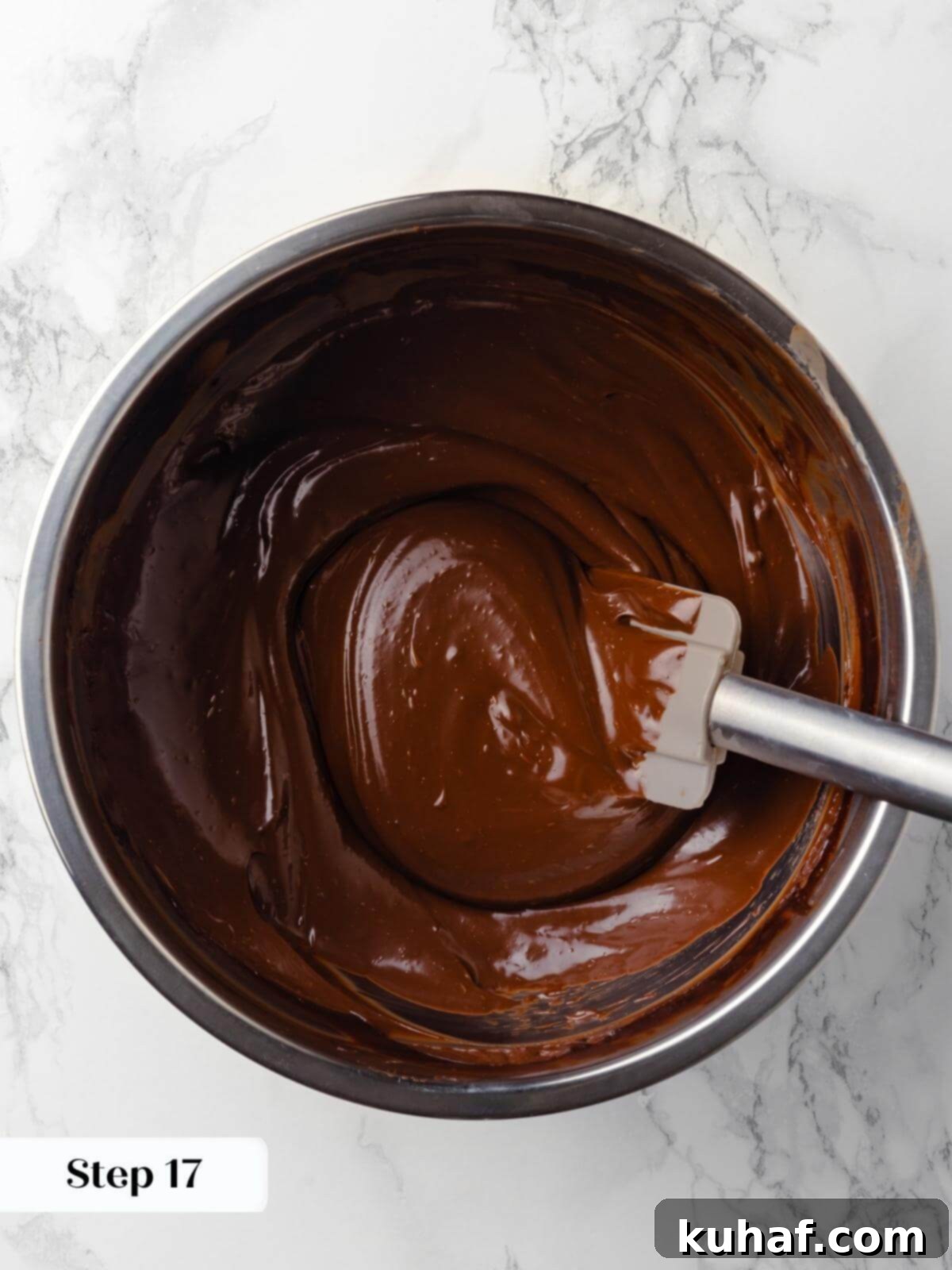A bowl of silky, dark chocolate ganache, freshly mixed and glossy, prepared to become the rich fudge frosting for the cake.