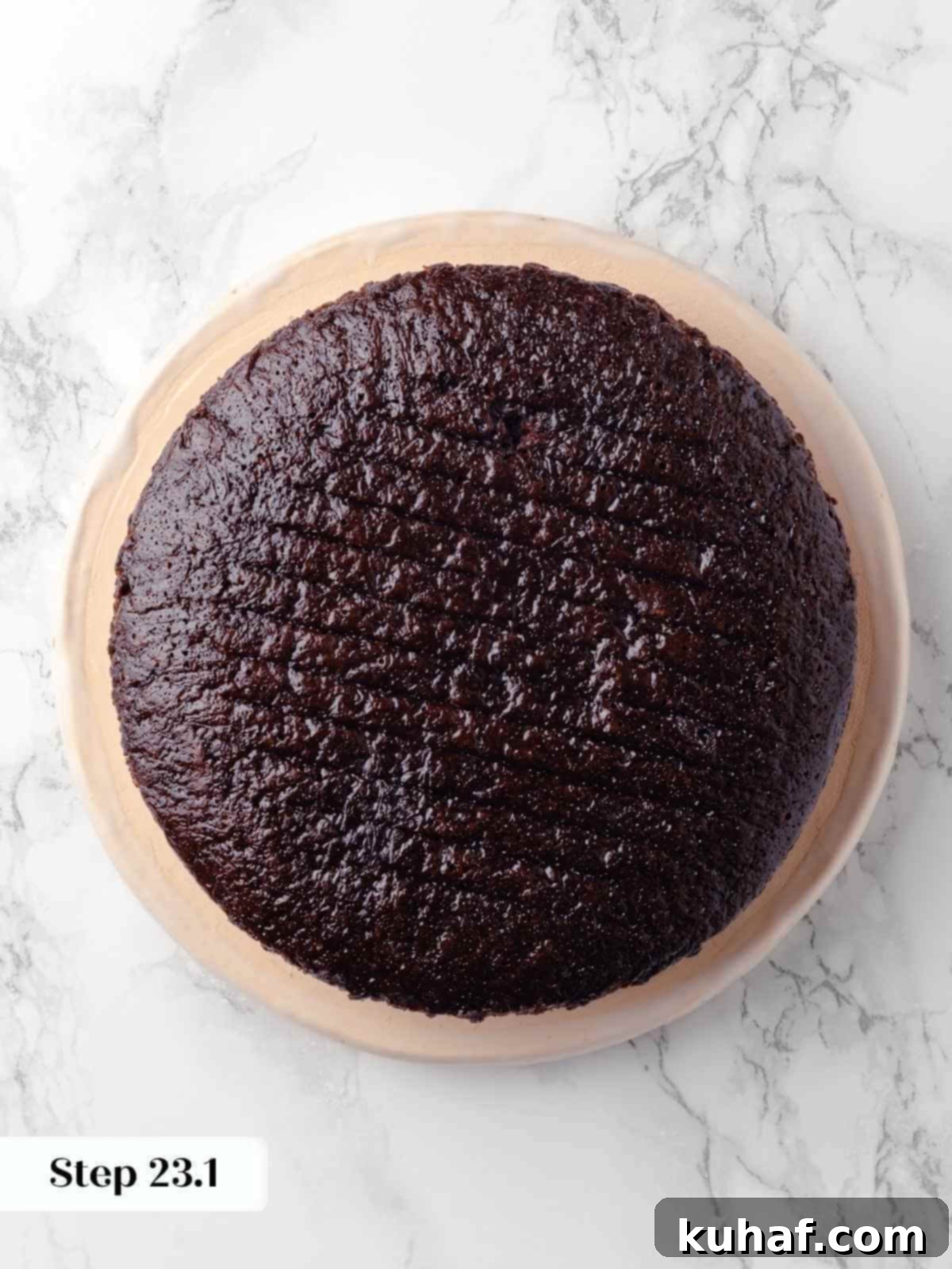 The first dark chocolate cake layer placed on a serving plate, perfectly flat and ready to be adorned with fillings.