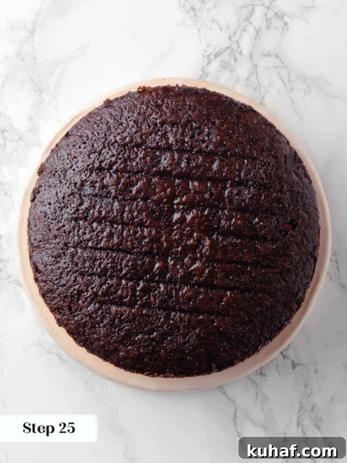 The second layer of the chocolate raspberry cake, placed precisely on top of the first filled layer, awaiting its own delicious fillings.