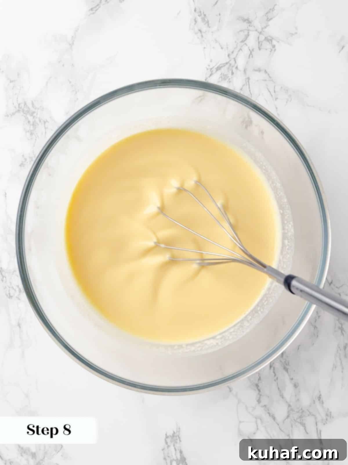 Vanilla extract or paste being gently whisked into the tempered custard mixture, adding essential flavor to the crème caramel.