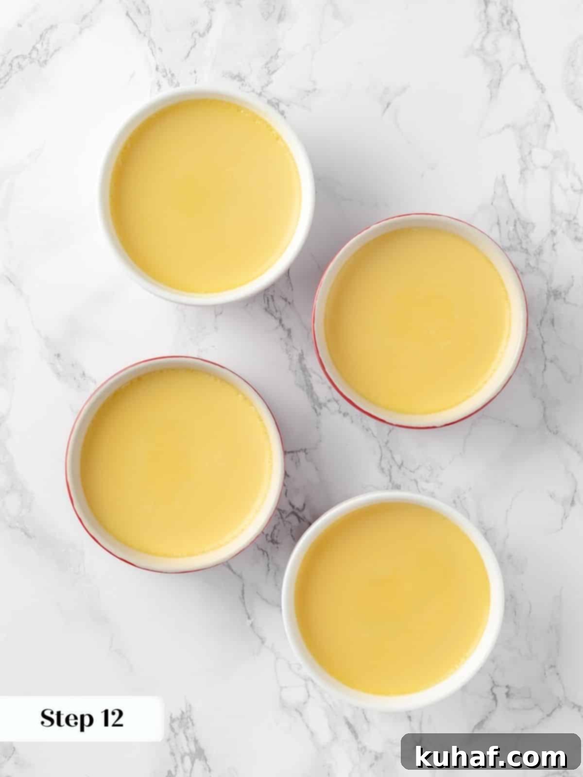 Crème caramel custards baking gently in a water bath, covered with foil, ensuring a smooth, even cook.