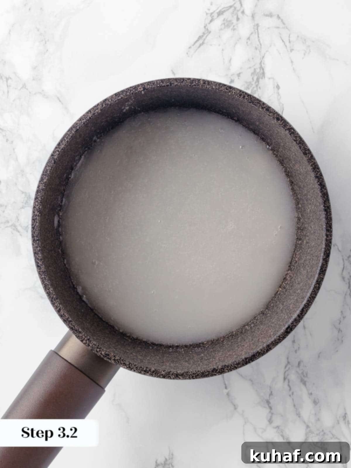 Water being added to melted sugar in a pan to create a wet caramel for the creme caramel.