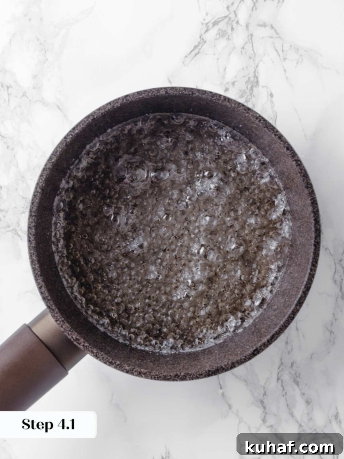 Sugar bubbling and swirling in a saucepan, progressing towards a rich amber caramel color.