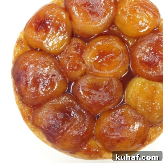 A perfectly caramelized Tarte Tatin, with golden apples arranged beautifully under a golden puff pastry crust.