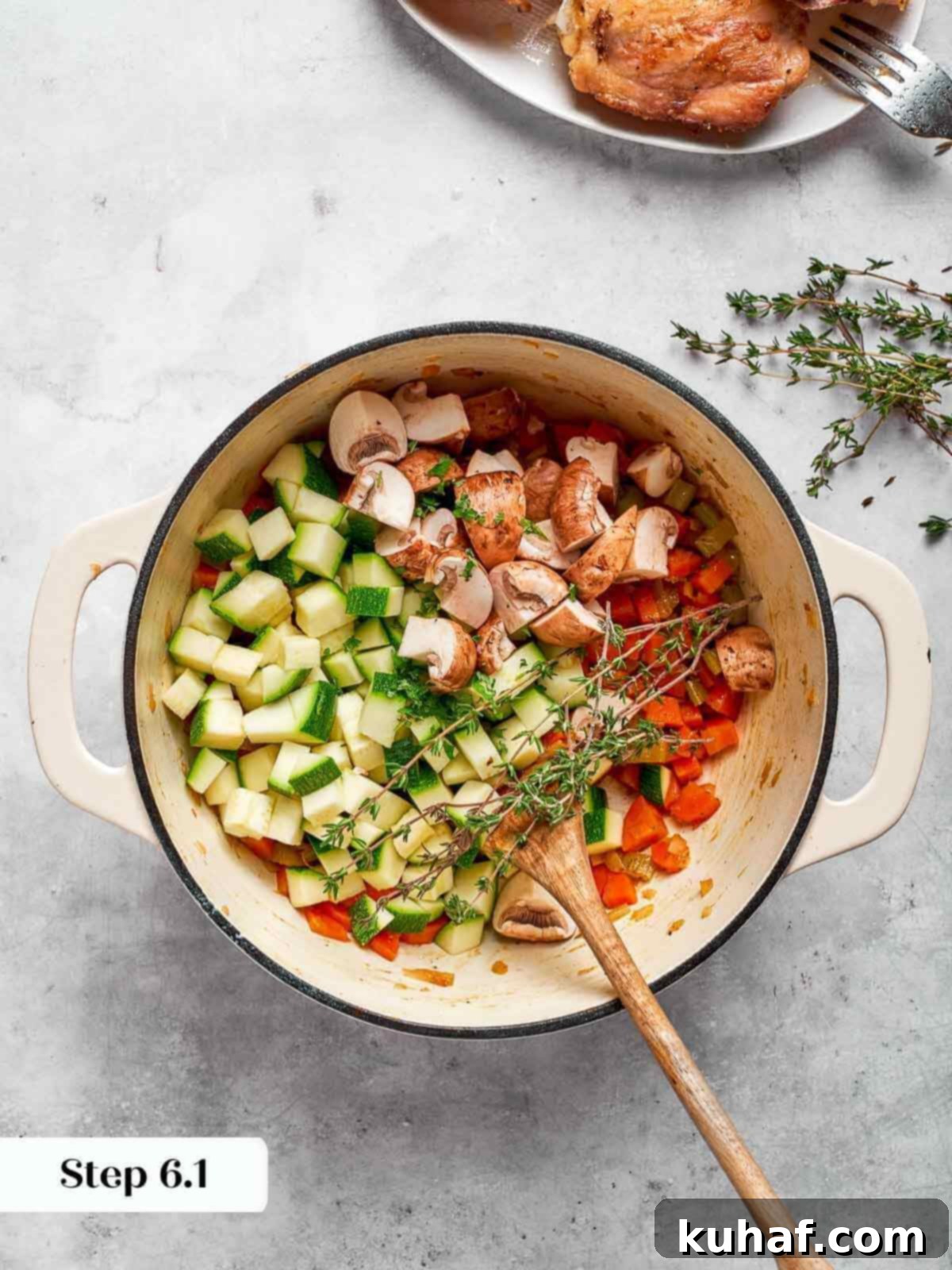 Comforting Chicken Garden Soup 9 Fresh zucchini pieces being added to the vegetable soup mixture in the pot.