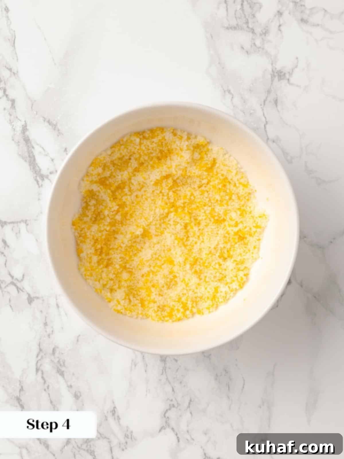 A small bowl of sugar and orange zest being combined.