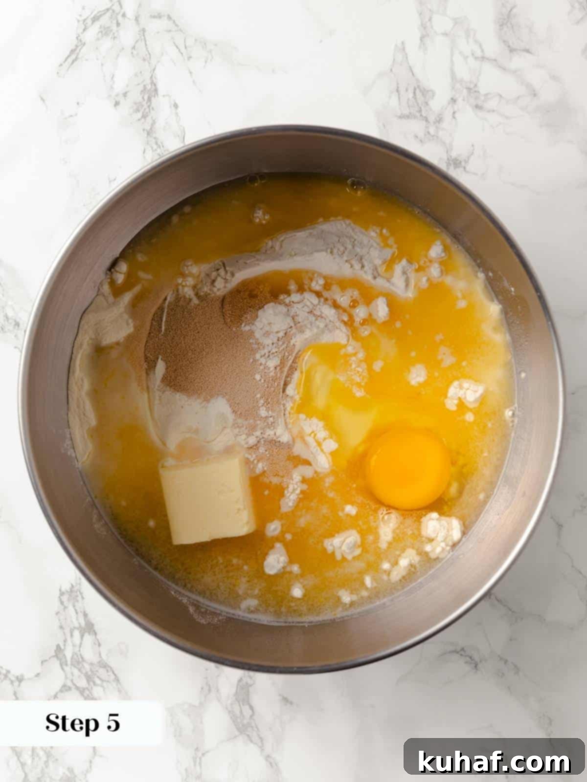 Ingredients for sticky bun dough mixed in a large bowl.