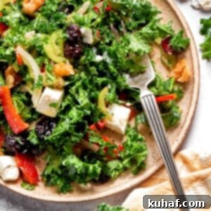 Bright and colorful chopped kale salad with cranberries, feta, and walnuts, ready to be served.