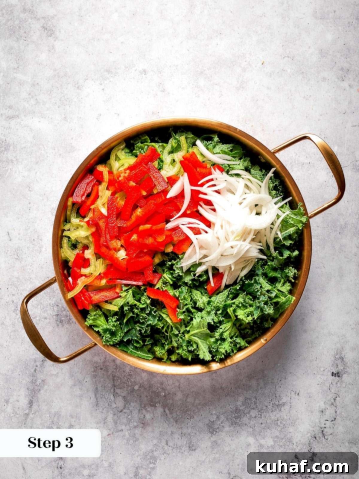 A large mixing bowl filled with vibrant, freshly chopped kale, thinly sliced onions, and colorful peppers, ready for the dressing.