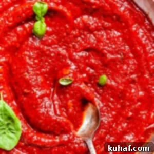 Perfect Homemade Pizza Sauce 10 Rich tomato sauce clings to a spoon, ready to top a fresh crust.
