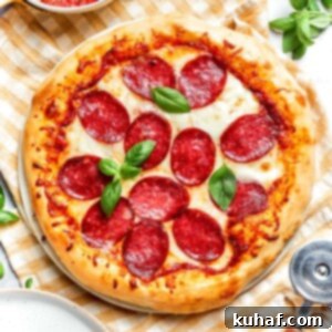 Close-up of golden, crisp crust on baked pepperoni pizza.
