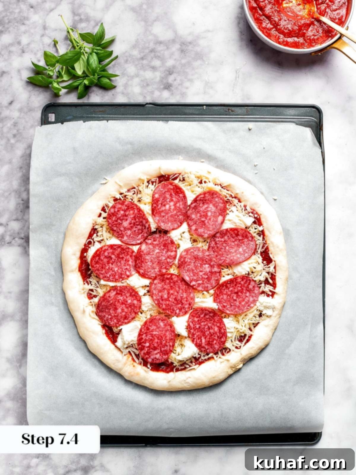Arranging pepperoni slices on top of the cheese layer.