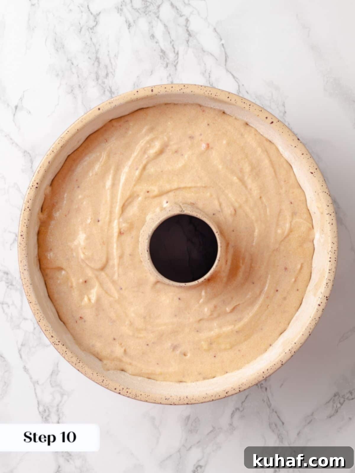 Cake batter smoothed into a bundt pan, ready for placement in the oven for baking.