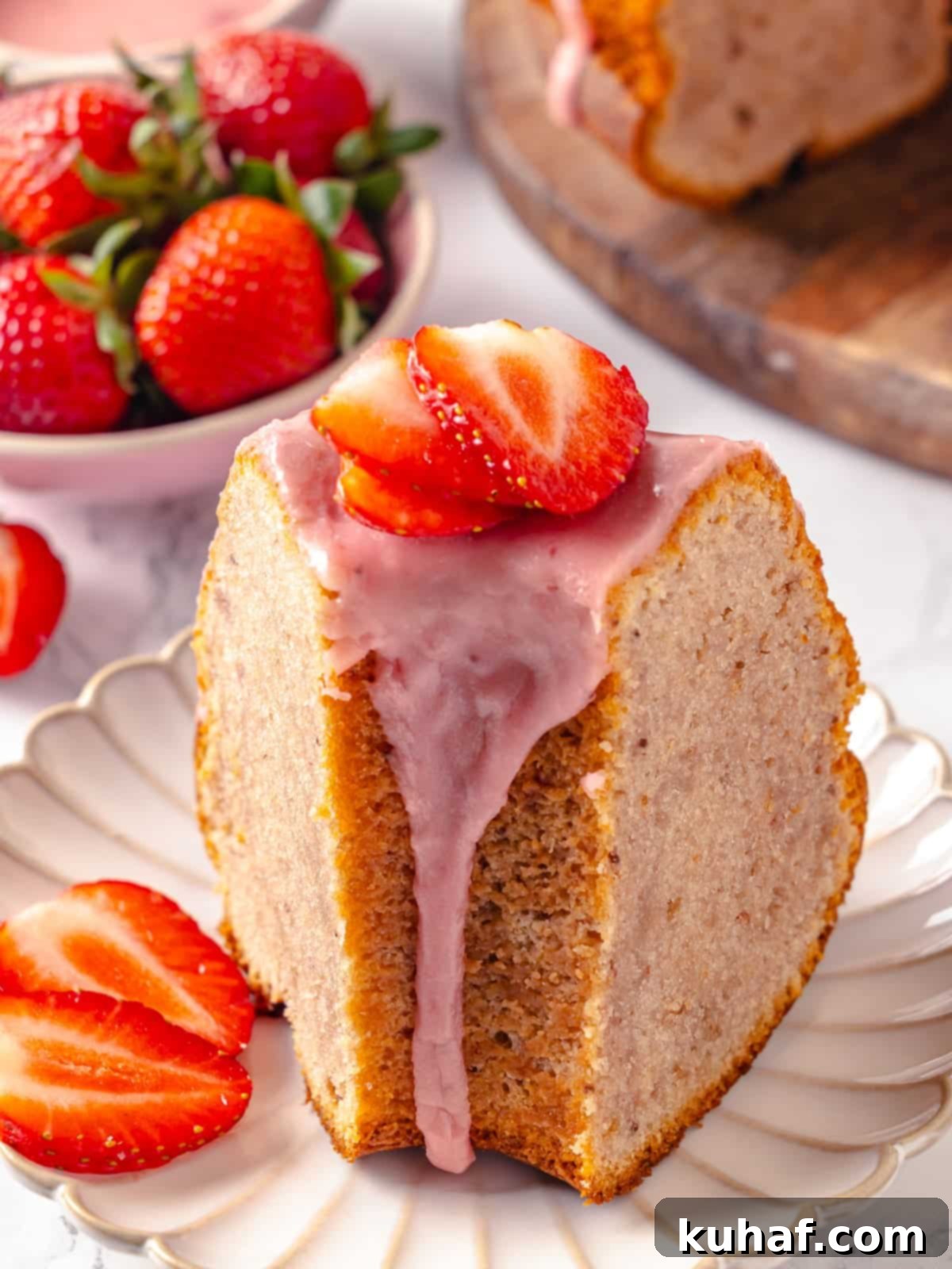 Slice of pound cake served on a white plate with glaze subtly dripping down the side, inviting a taste.