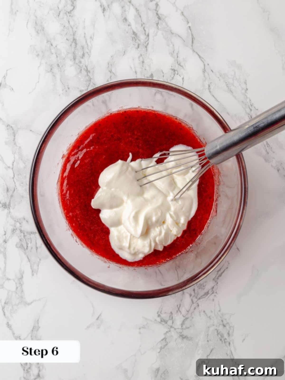 Sour cream being added to strawberry jam, creating a creamy and tangy component for the cake batter.
