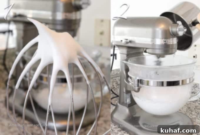Close-up of egg whites whipped to soft peaks on a silver whisk.