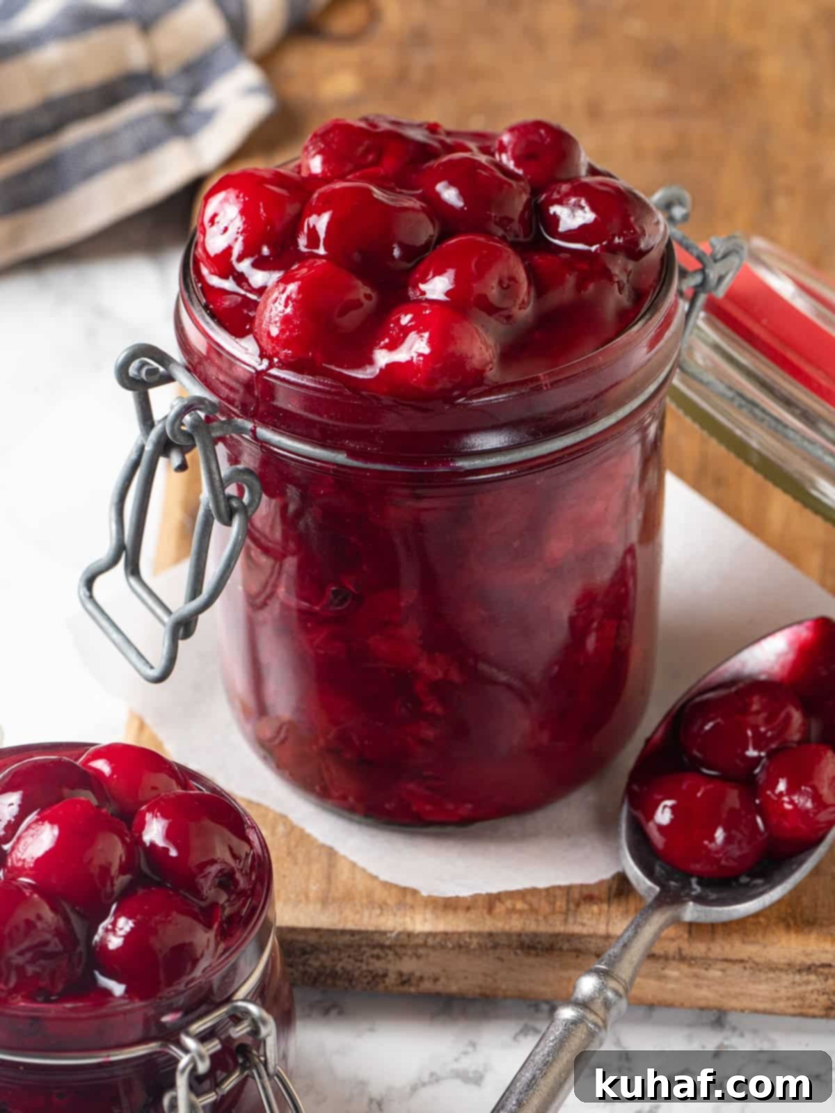 Jar filled to the top with cherry pie filling, syrup bubbling around the cherries.